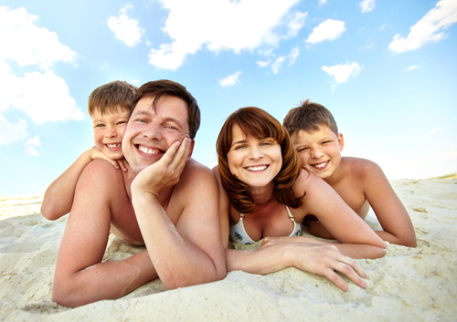 family resting on the beach