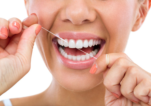 woman flossing her teeth