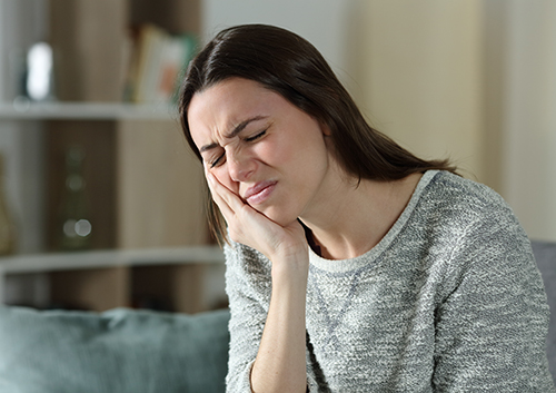 Woman complaining suffering toothache at home