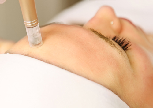 Beautician cosmetologist doing procedure fractional microneedle