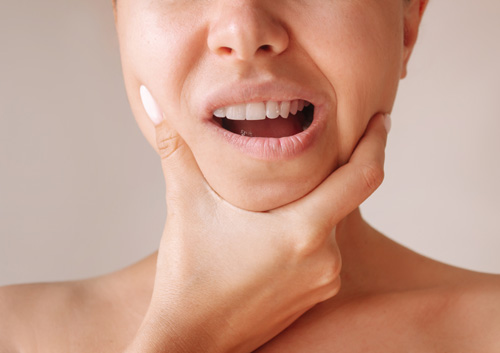 young woman suffering from jaw pain